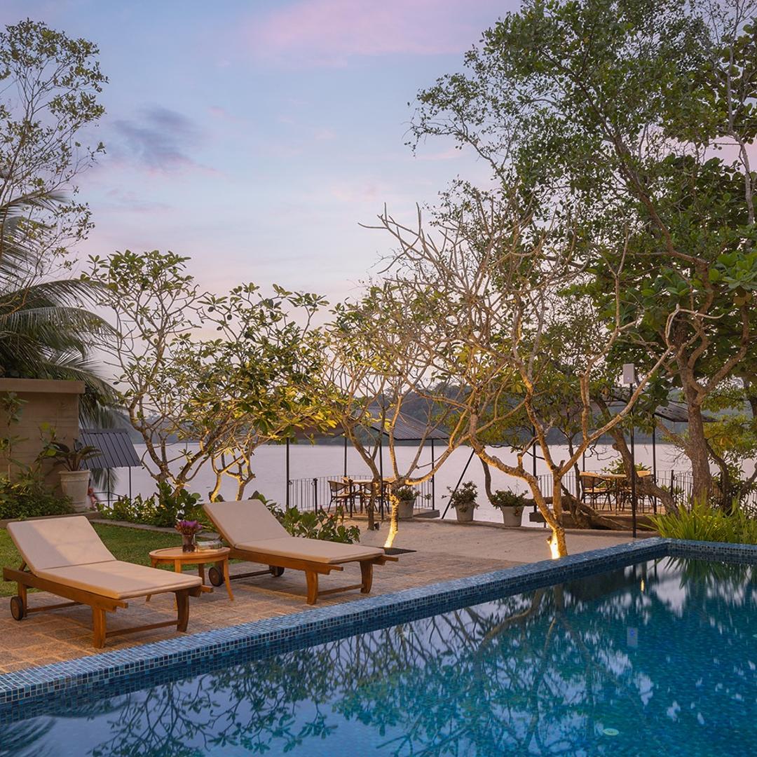 Yahva Bentota villa pool deck with sun loungers at sunset beside Dedduwa Lake