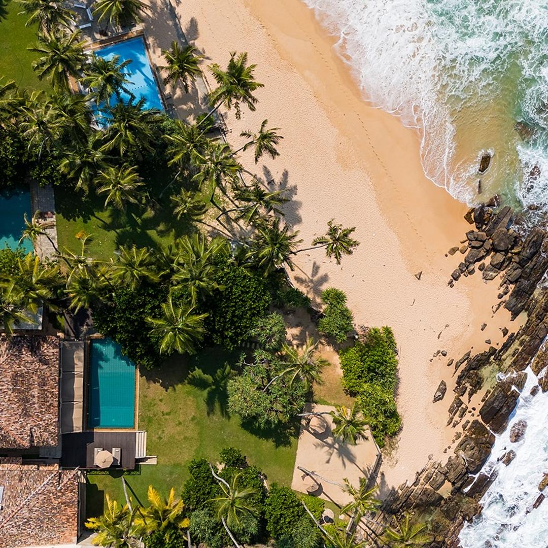 Aerial drone view of On The Rocks Unawatuna villa on rocky beachfront Sri Lanka