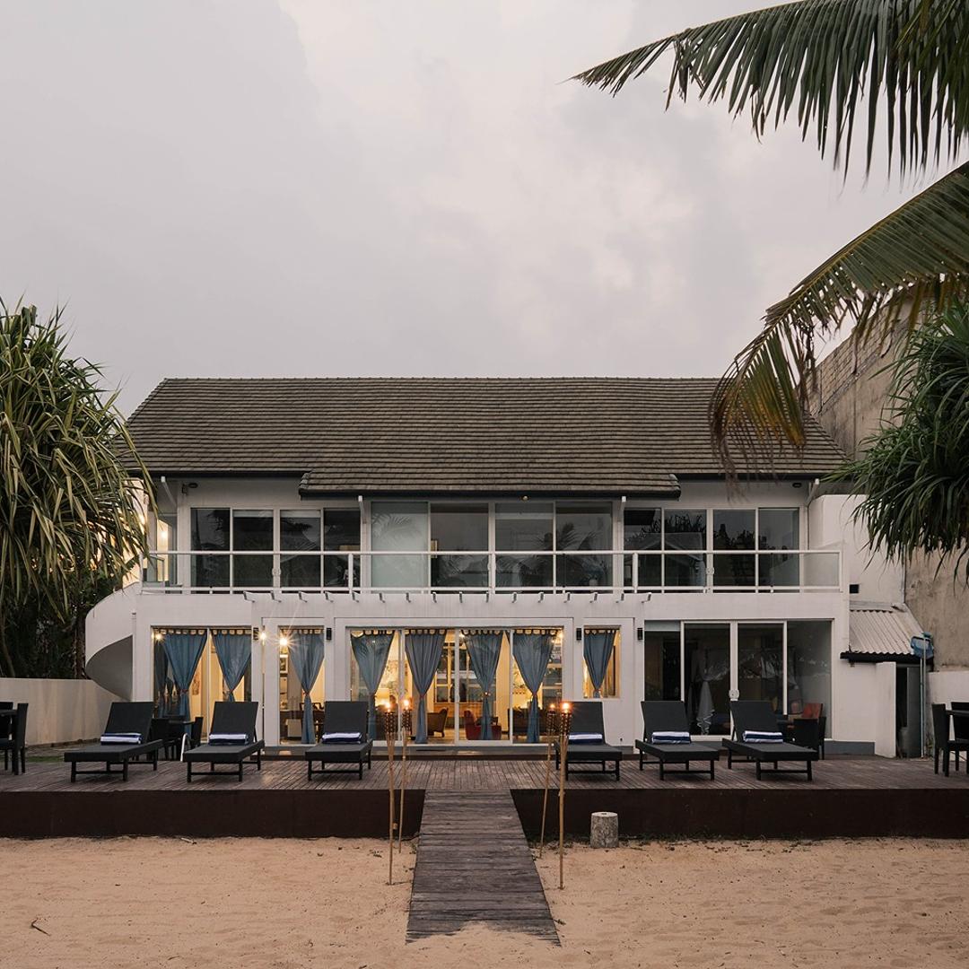 Briza Azul Mirissa exterior beach frontage with torches and pool at dusk