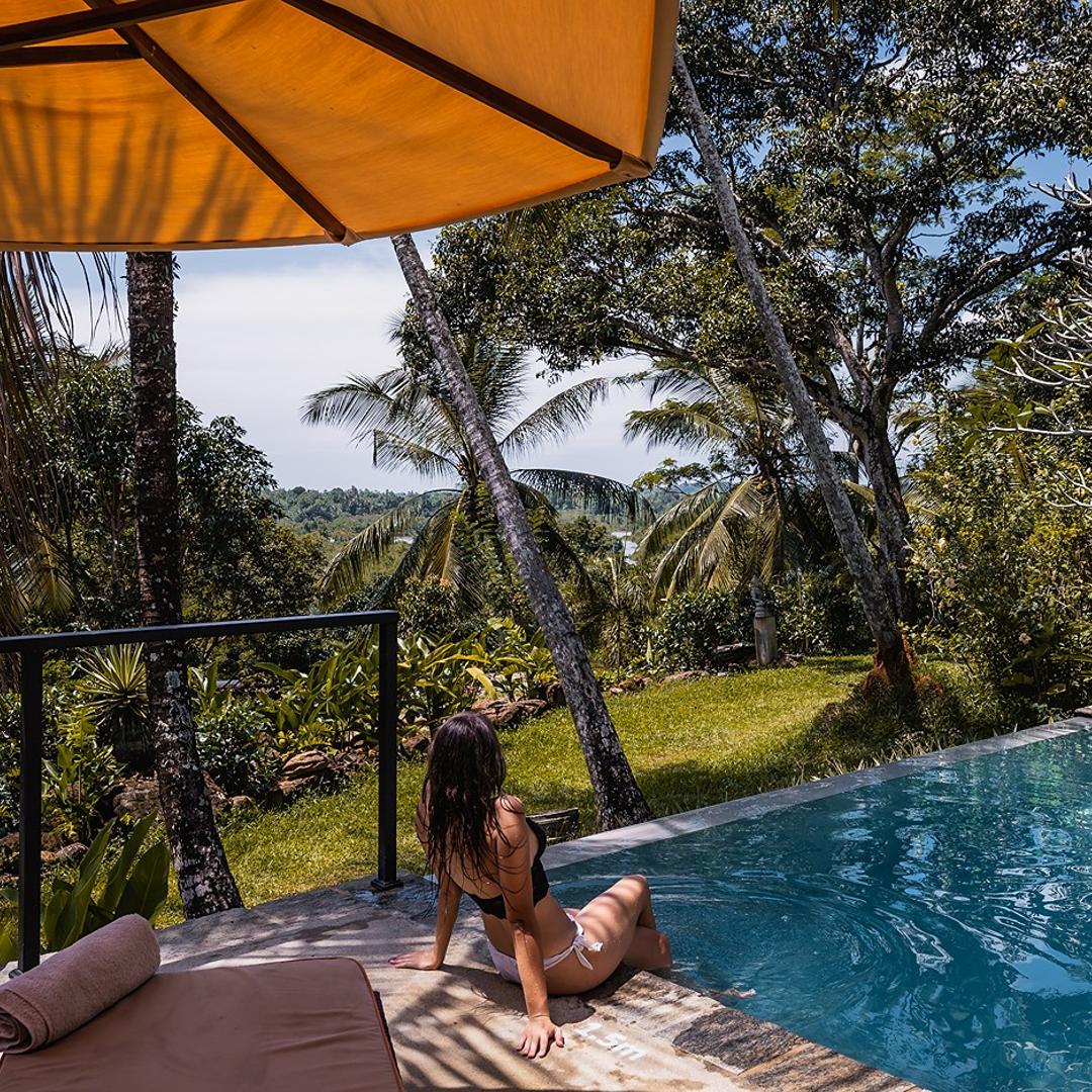 Pool daybed with canopy and tropical garden setting