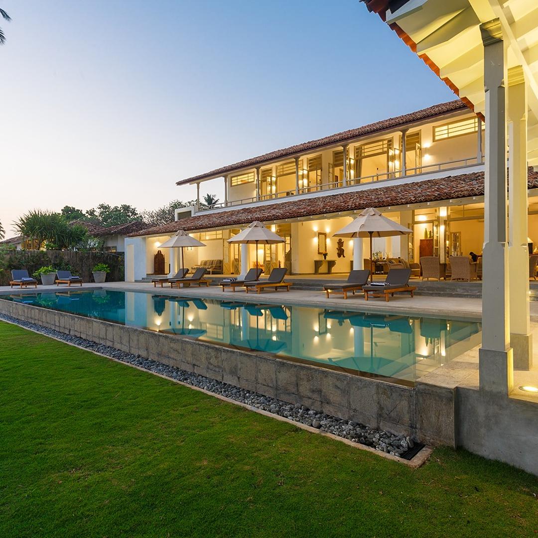 Villa Sulanga dusk facade with illuminated terrace and tropical lawns, Habaraduwa