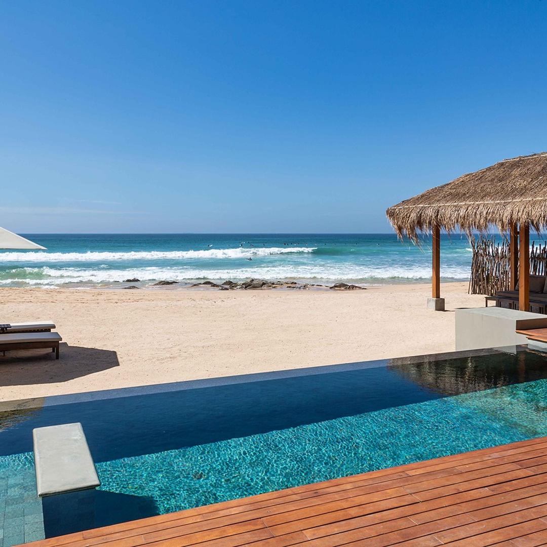 Wide daytime view of The Six Weligama pool with pavilion and beach, Midigama, Sri Lanka