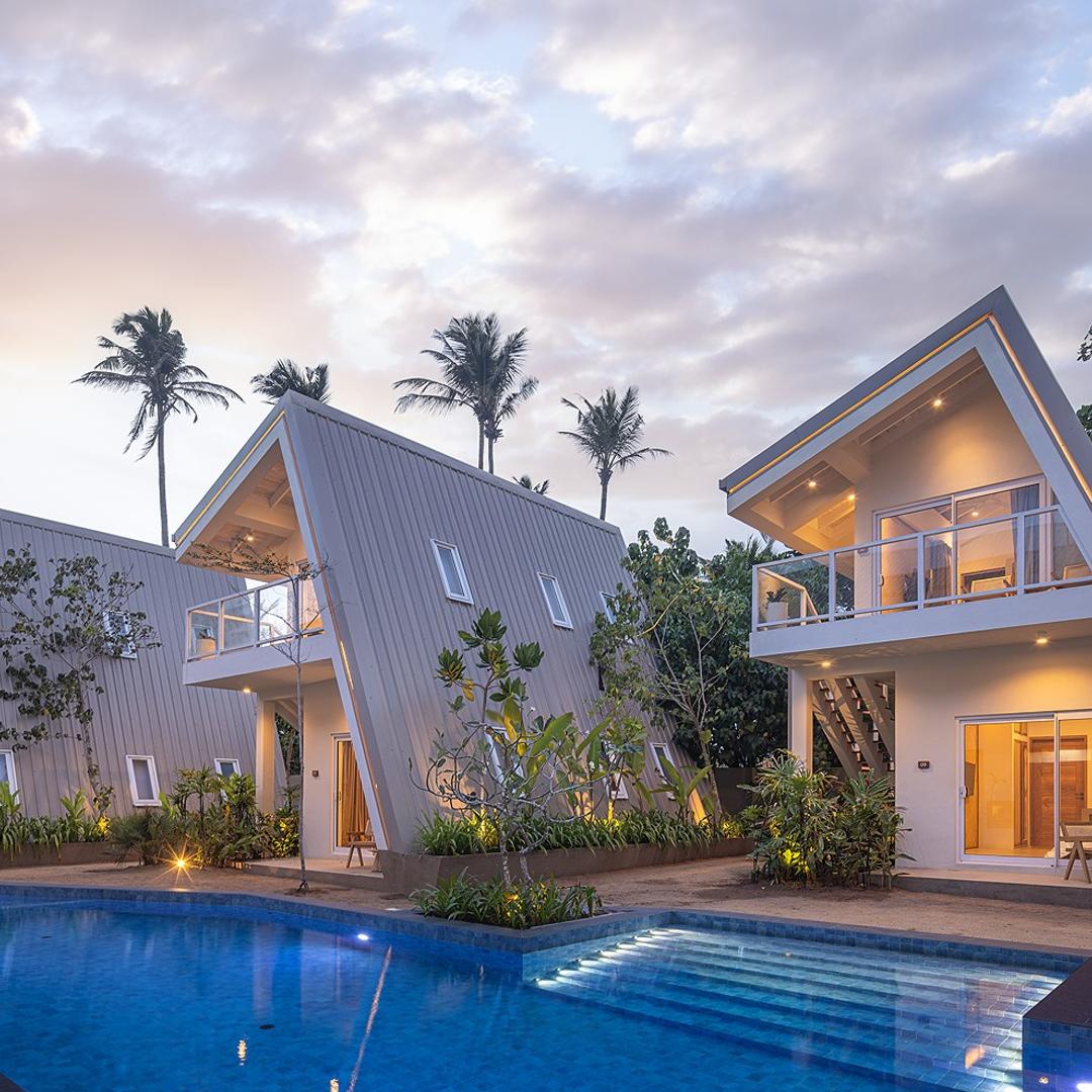 Asaya Sands Mirissa pool and A-frame chalets at dusk with palms, Mirissa, Sri Lanka