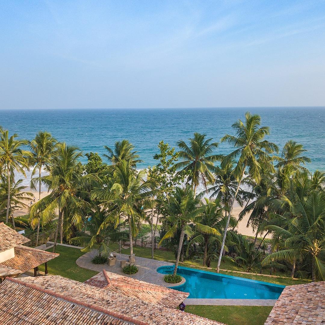Aerial of Abiman Dickwella villa and pool from front with beach, Dickwella, Sri Lanka