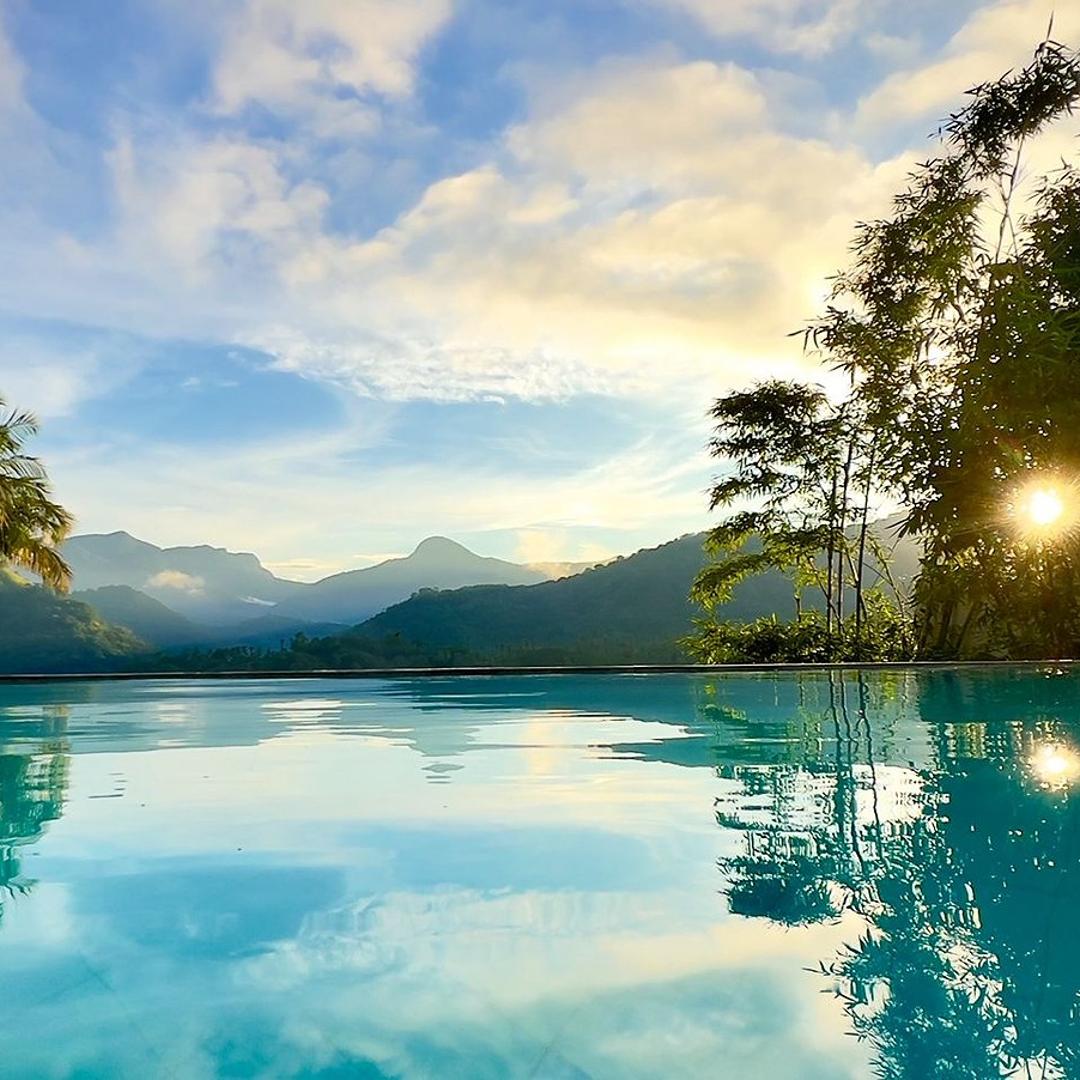 Pool with palms and mountains at golden hour, Glasshouse Victoria, Digana, Sri Lanka