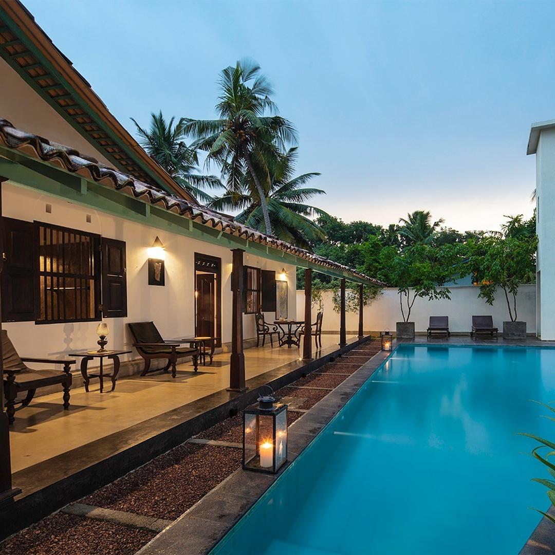 Pool with colonnade at dusk, Magalla Casa Galle