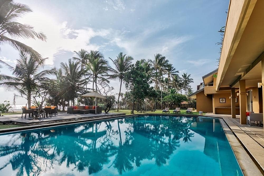 Wadduwa Beach Villa private pool lined with palm trees under a tropical blue sky