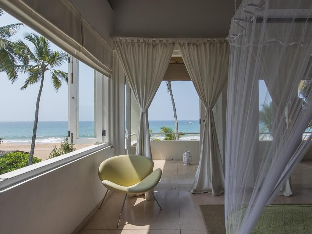 King suite sitting area with lounge chair and direct ocean view in Induruwa