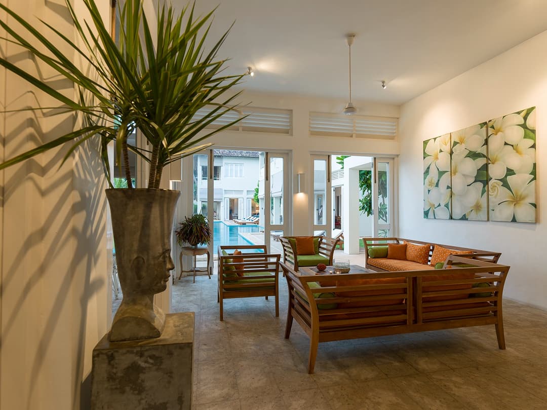 Araliya wing open-plan living room with orange accent chairs and high ceilings