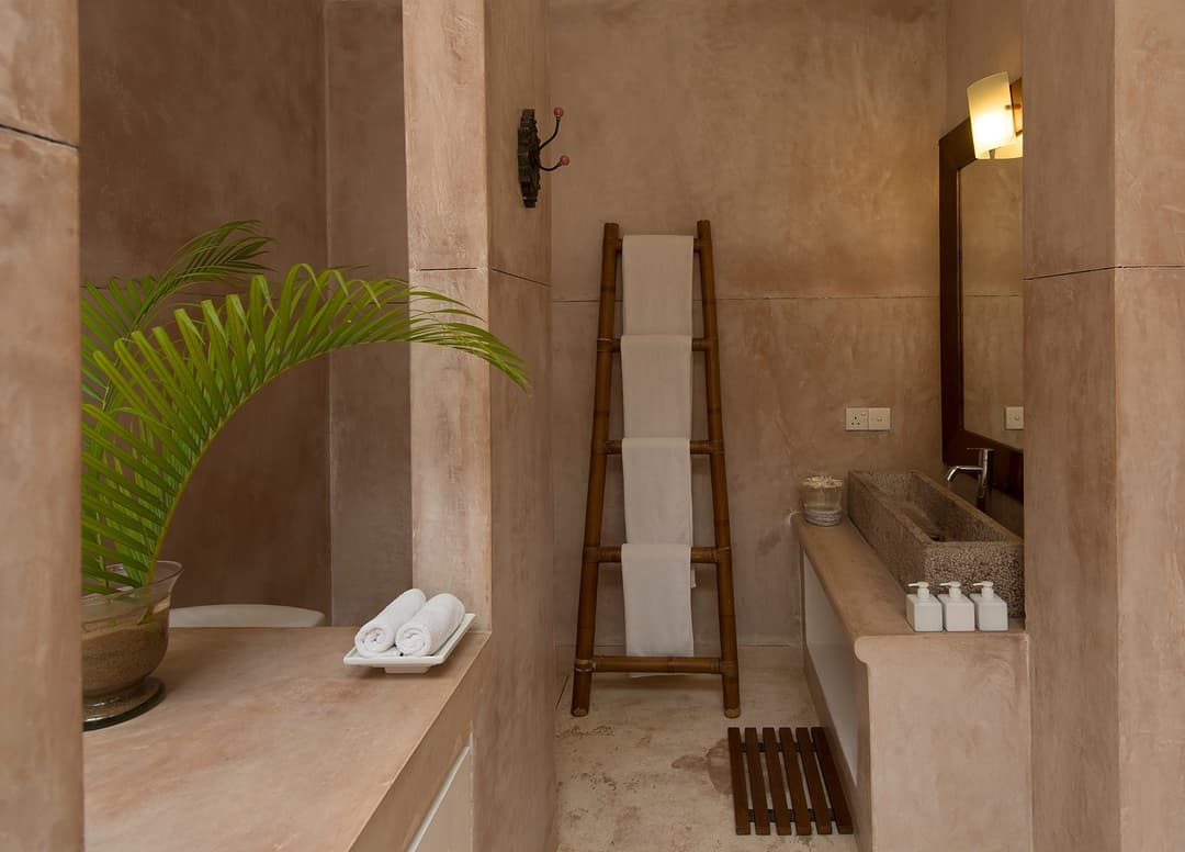 Nisala wing ocean suite bathroom with stone basin and warm ambient lighting