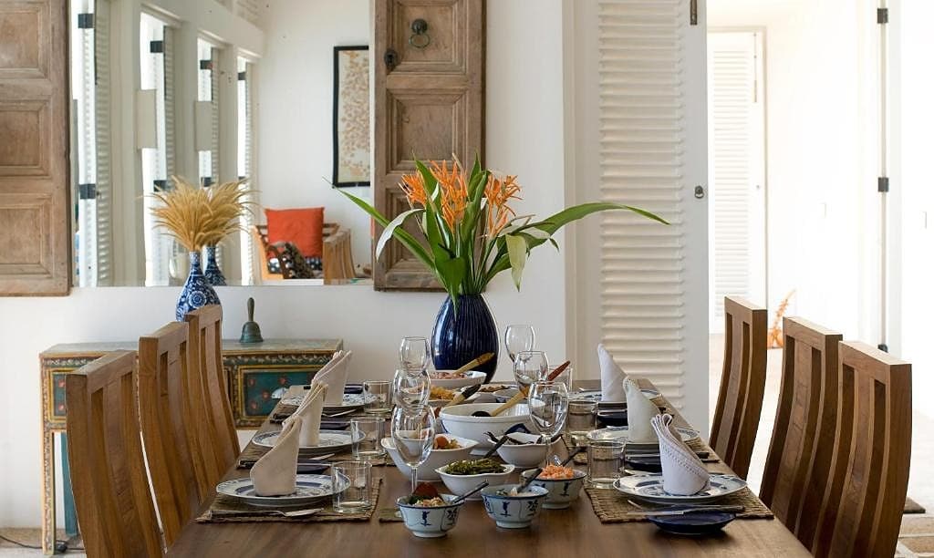 Villa open-air dining pavilion with formally set table and garden backdrop