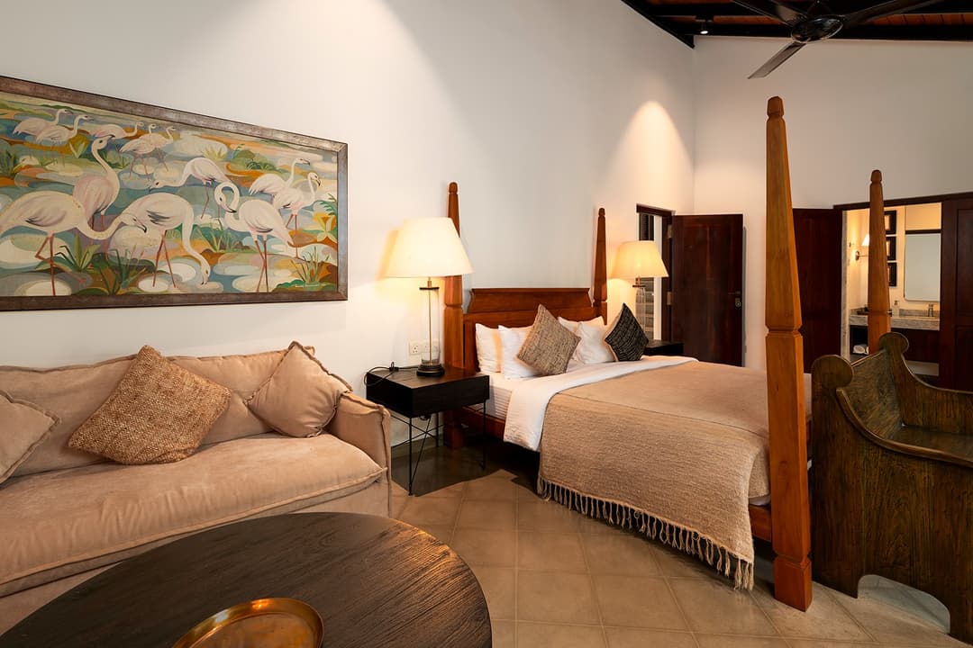 Villa bedroom sitting area with heritage table lamps and garden outlook