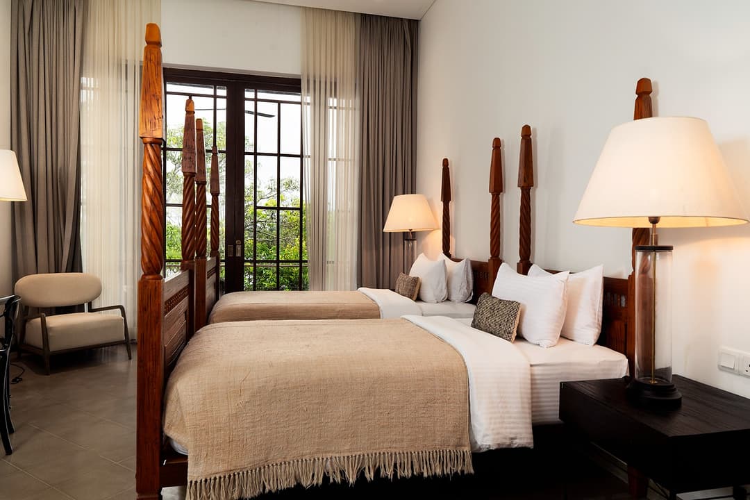 Villa bedroom with four-poster bed and heritage decor overlooking Bolgoda Lake