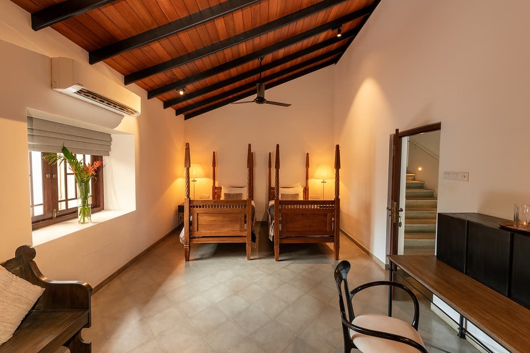 Villa bedroom with louvred windows, colonial-style furniture and warm lighting