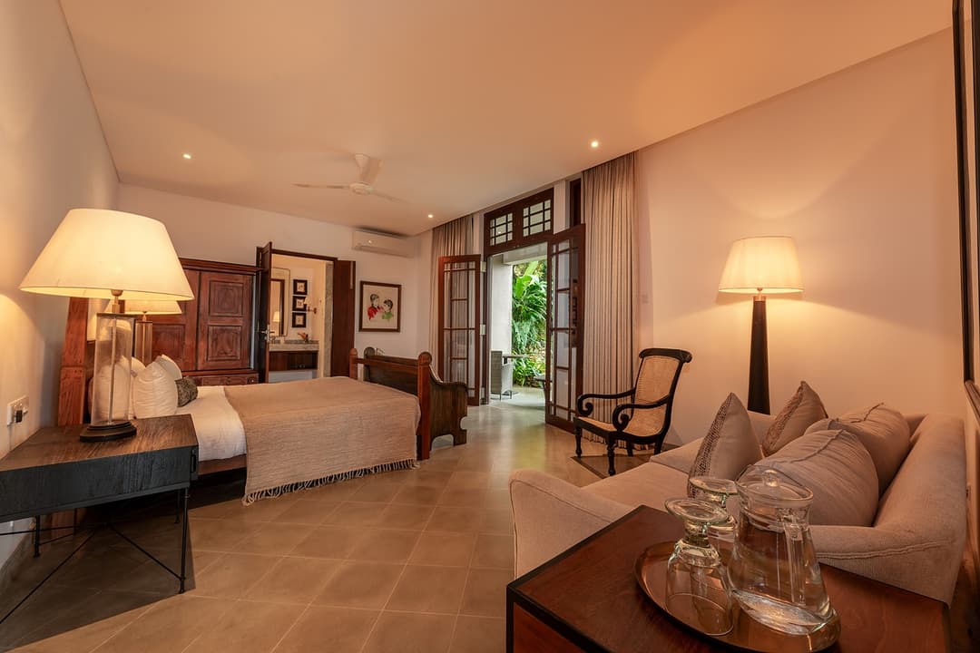 Lakeside villa king bedroom with timber ceiling, warm lighting and garden view