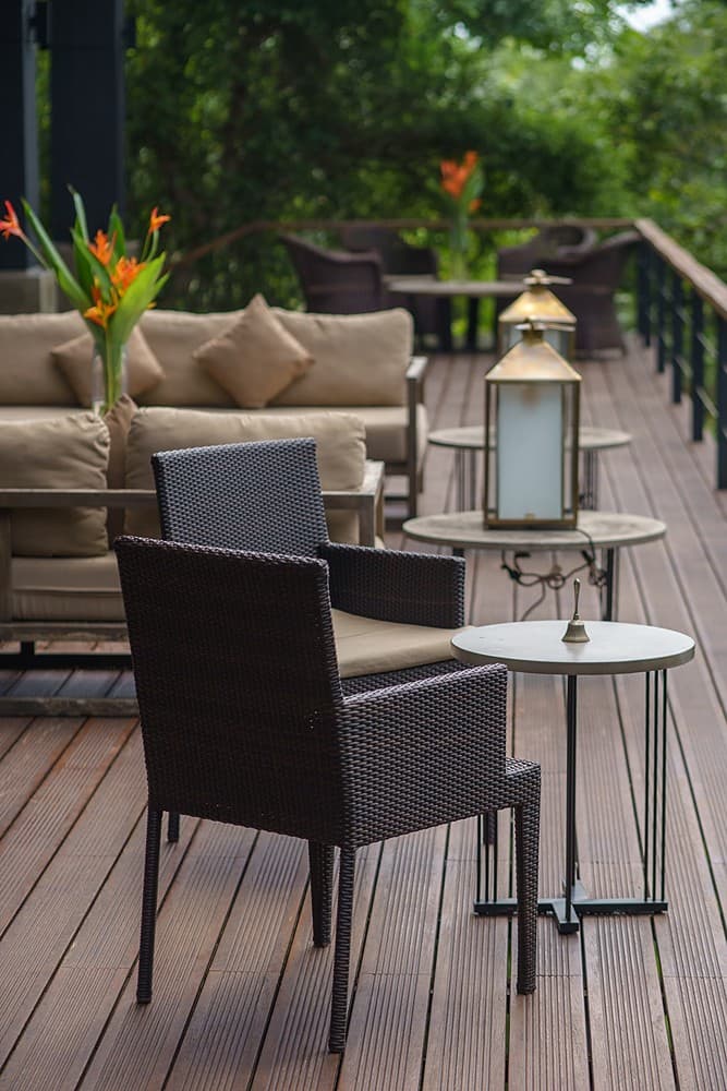 Villa deck with outdoor lounge chairs, lanterns and Bolgoda Lake views at dusk