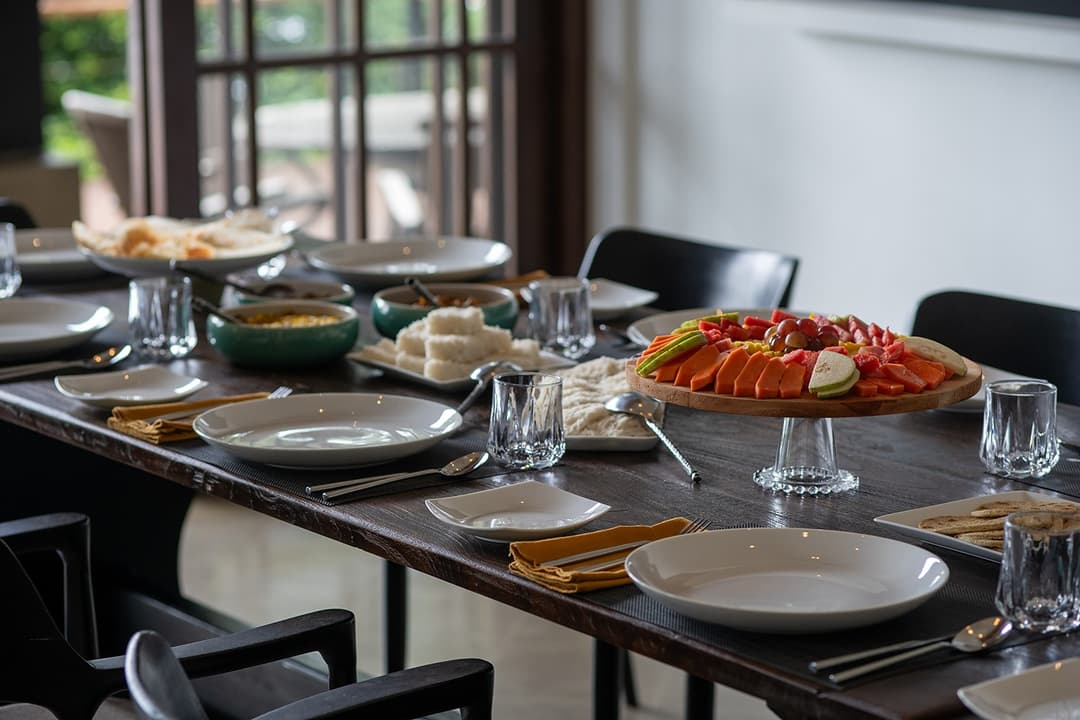 Lakeside villa dining room with formally set table and fresh breakfast feast