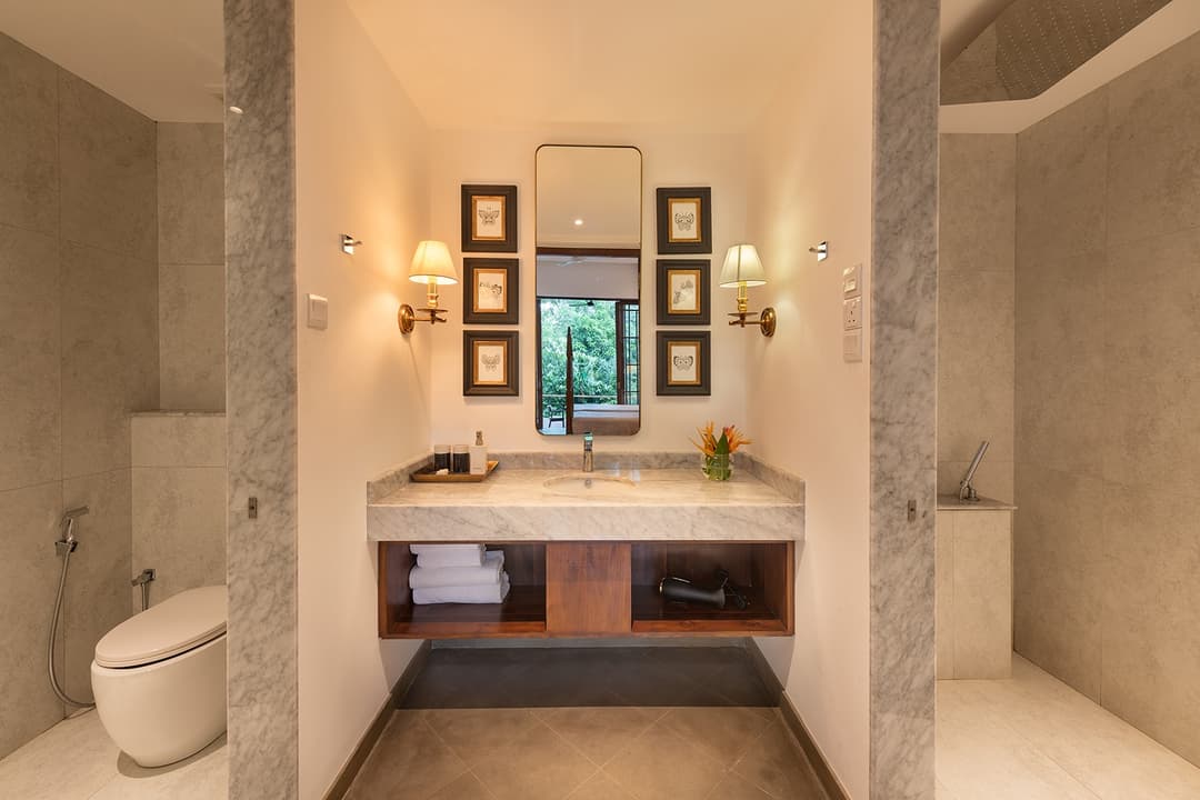 Villa ensuite bathroom with twin basins, large mirror and natural stone finishe