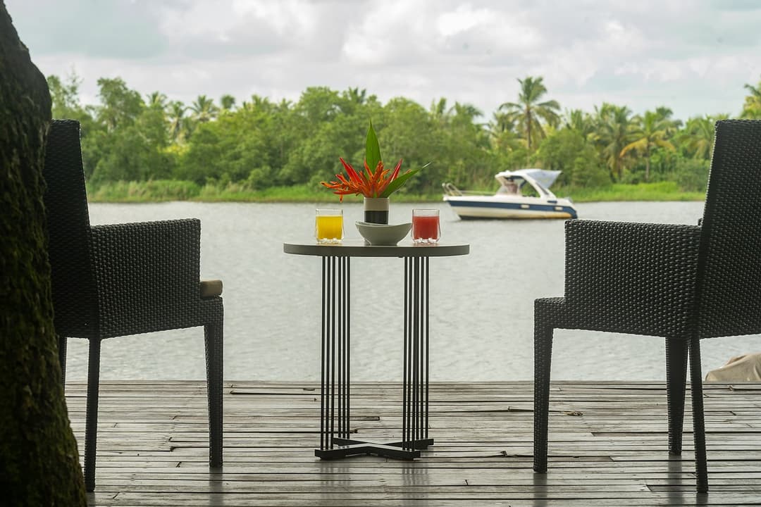 Villa lakeside dining table for two with calm Bolgoda Lake view and overcast sky