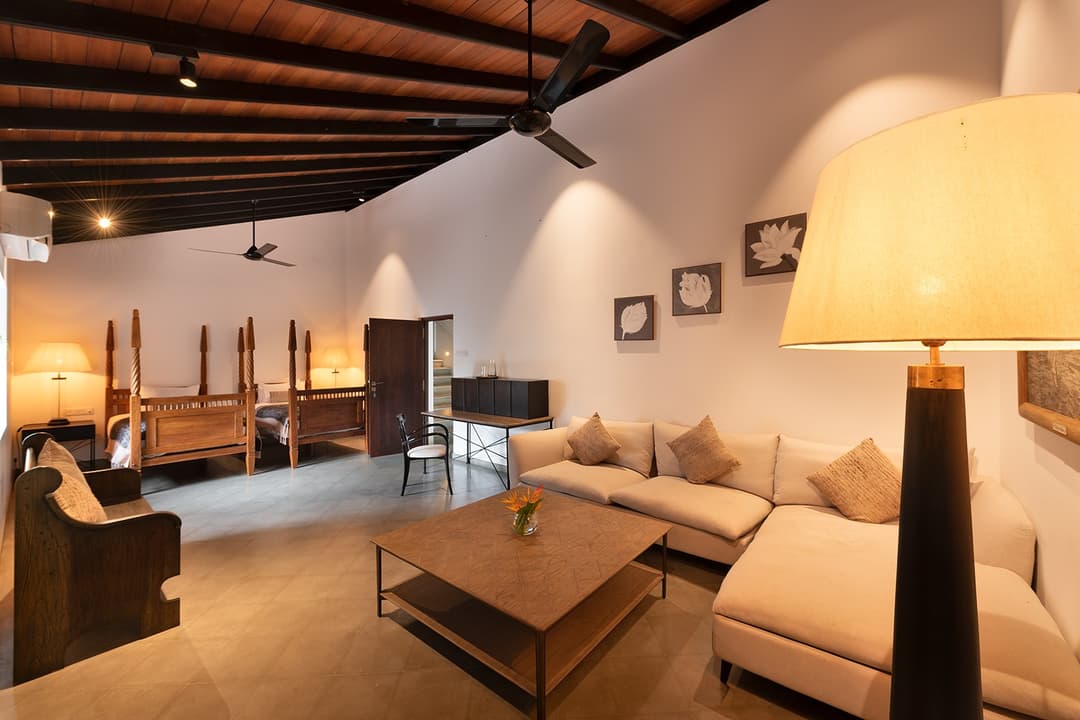 Villa lounge with black pendant lamp, colonial aesthetic and garden outlook