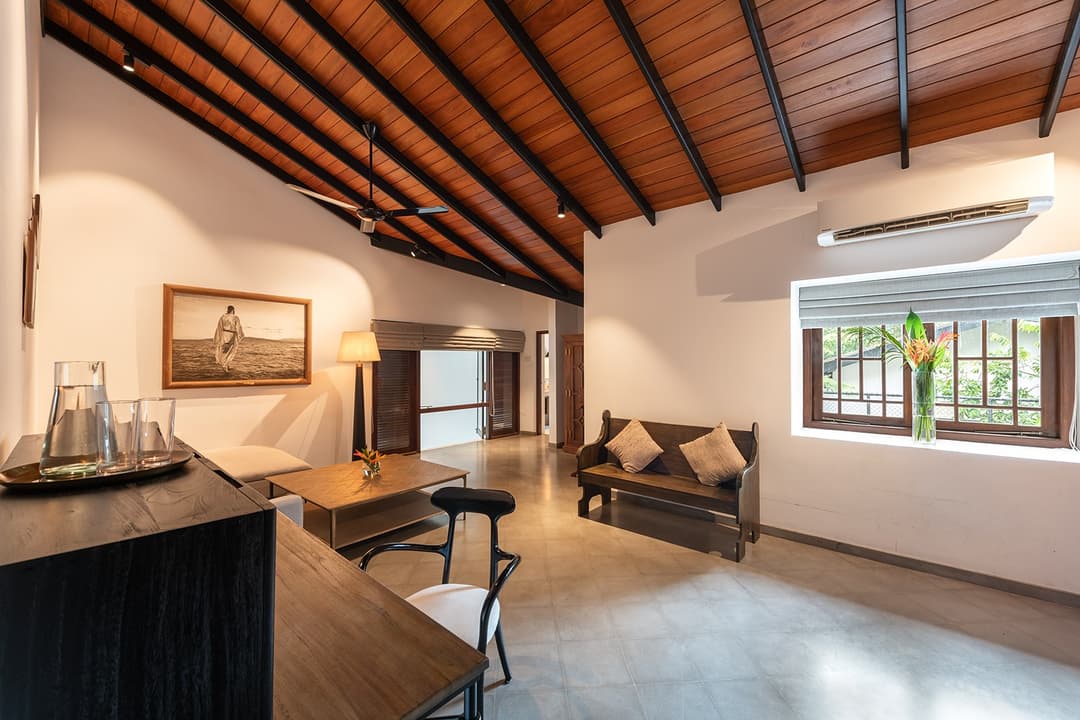 Bolgoda Lake villa master suite with heritage timber furniture and high ceilings
