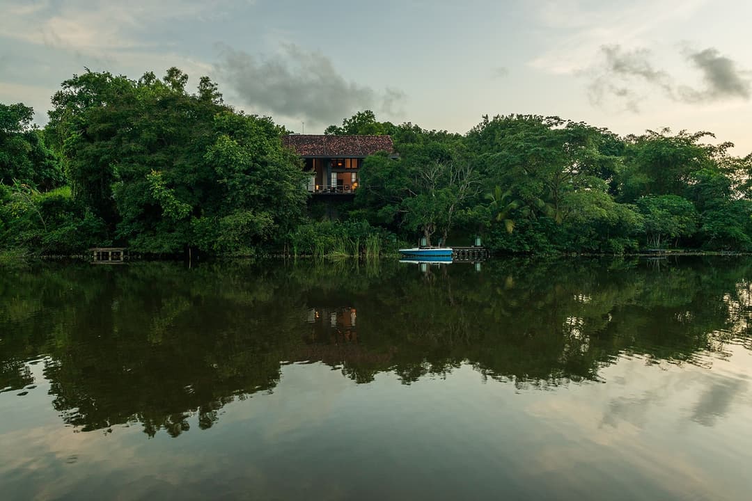 Celeste Bolgoda mirror-like lake reflection with tropical garden in foreground
