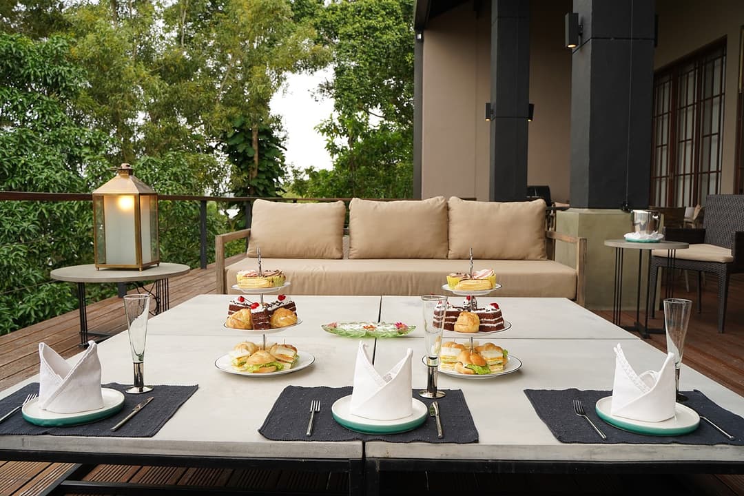 Celeste Bolgoda outdoor lounge with set dining table and Bolgoda Lake garden view