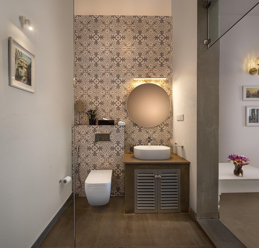 Villa bathroom with freestanding vessel basin, circular mirror and Moroccan tiles