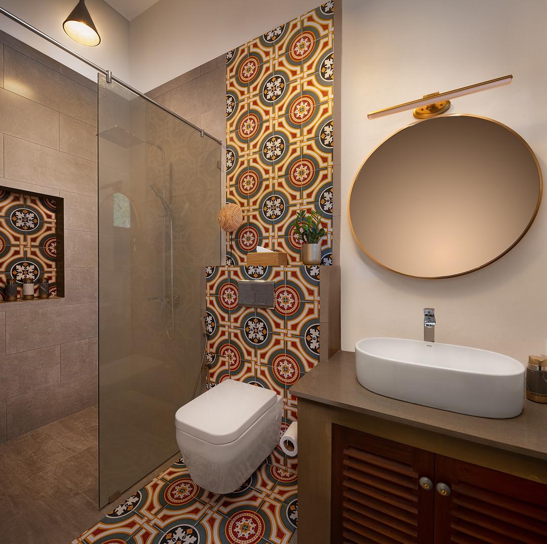 Villa bathroom with hand-painted Moroccan tiles and large circular mirror
