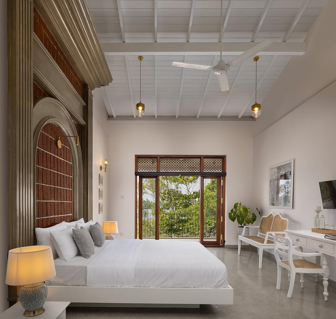 Villa bedroom with arched ceiling, pendant lights and double aspect windows