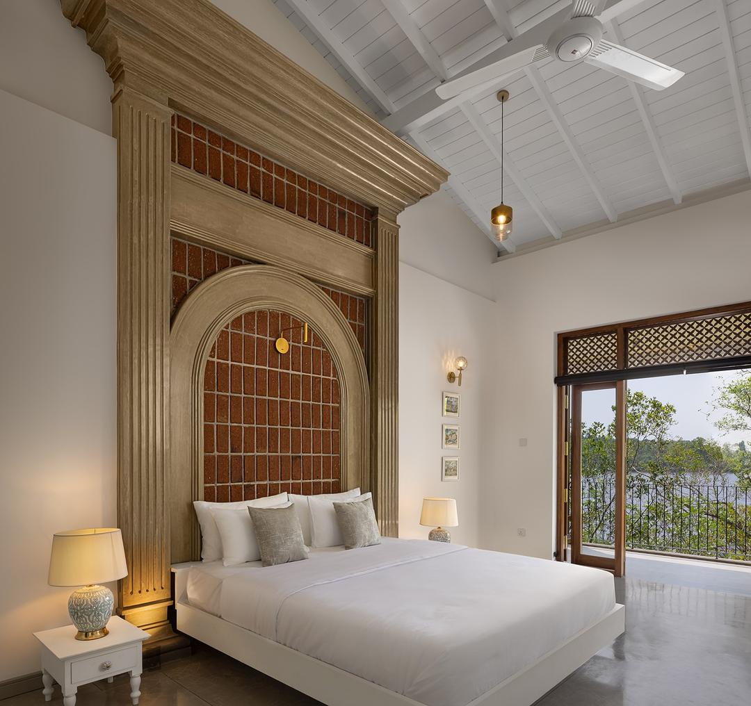 Villa bedroom with ornate arched doorway and garden views in Bentota