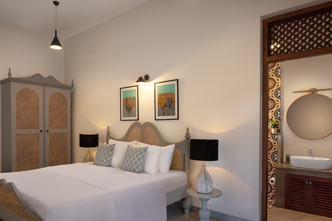 Villa bedroom with pendant lights, dark timber doors and white linen in Bentota