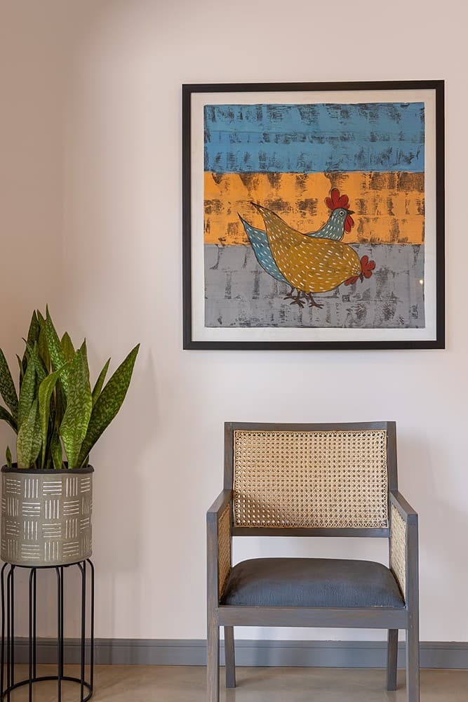 Villa bedroom sitting area with accent chair and original artwork in Bentota