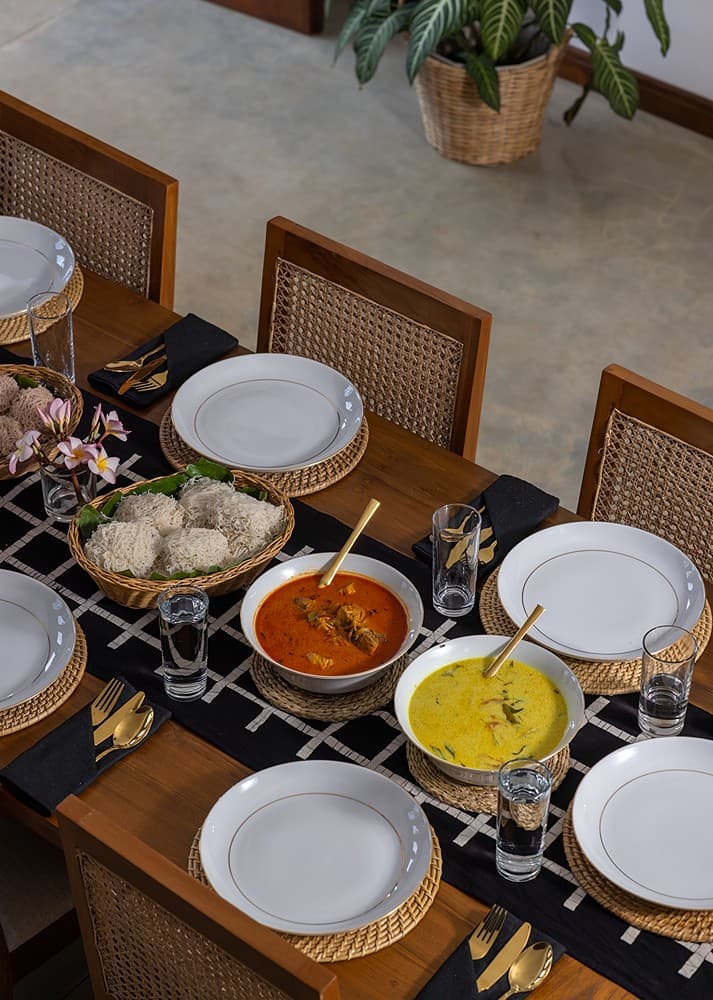Villa dining table set from above with fresh Sri Lankan dishes and flowers