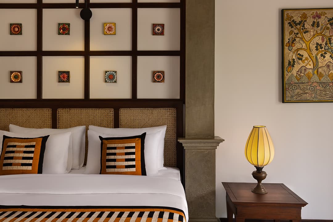 Villa bedroom with arched doorway, brass table lamp and terrace access