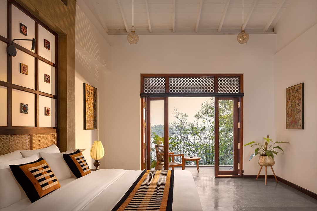 Villa king bedroom with ornate arched headboard wall and tropical garden view