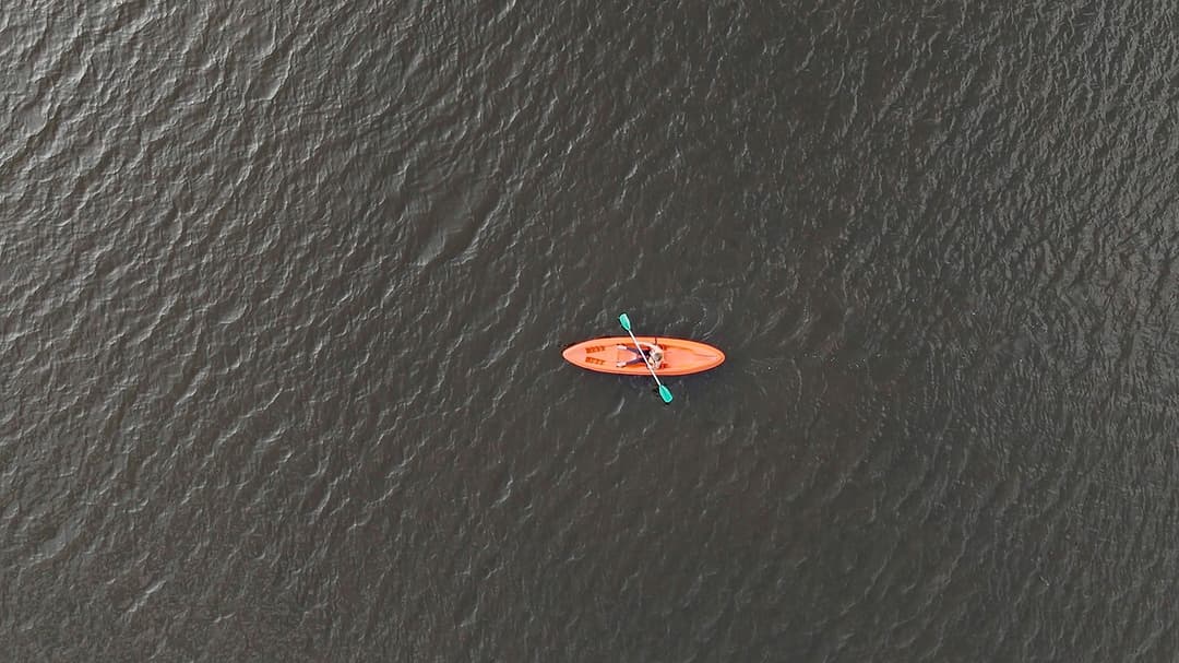 Aerial view of lone kayak on calm Dedduwa Lake waters in Bentota Sri Lanka