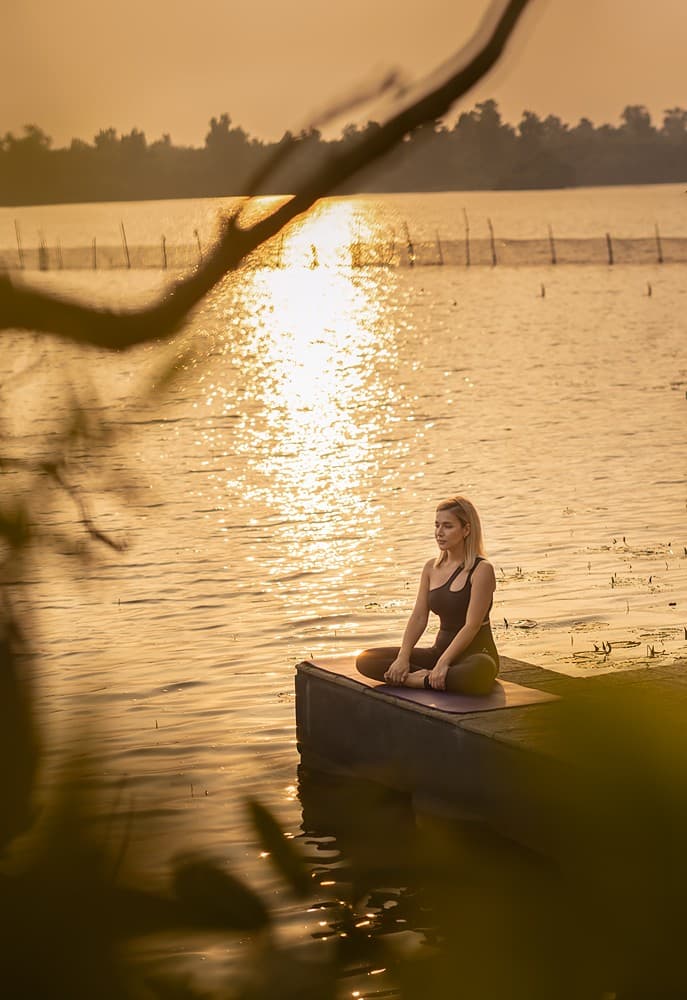 Person silhouetted at sunset on Dedduwa Lake golden hour Bentota Sri Lanka