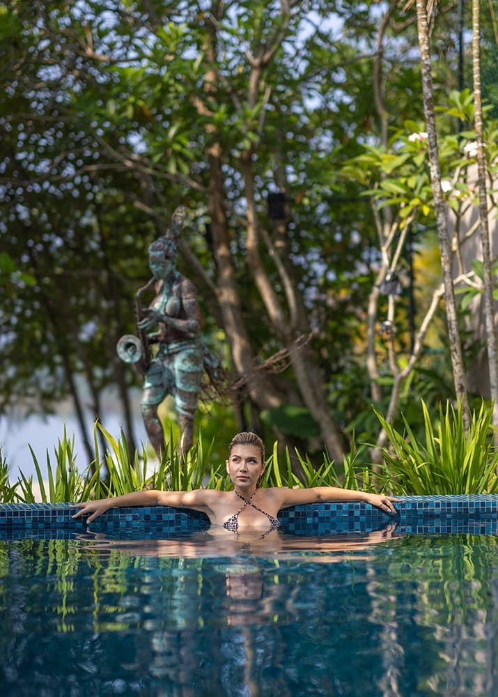 Yahva Bentota infinity pool extending toward Dedduwa Lake through tropical garden