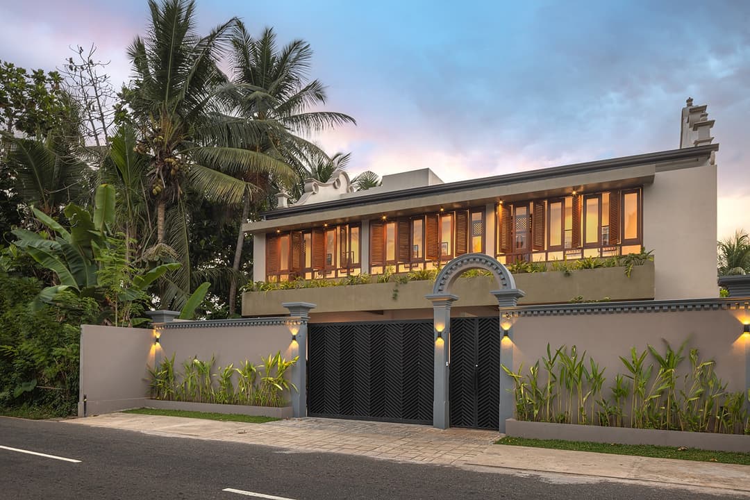 Yahva Bentota villa entrance road with black gates and mature tropical trees