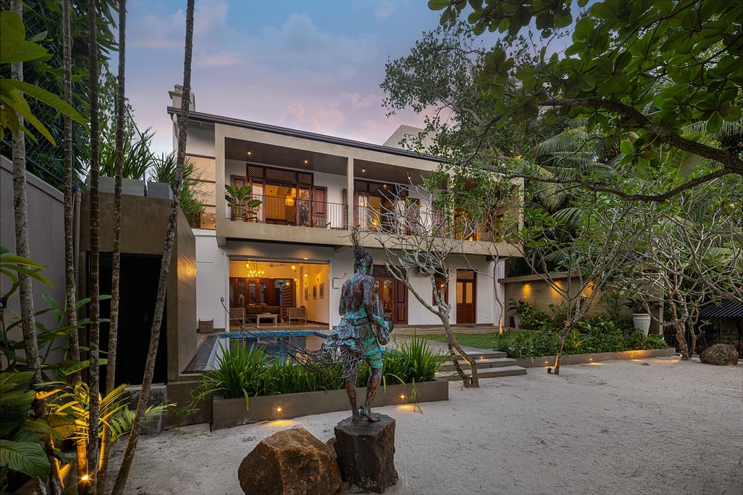 Yahva Bentota villa exterior with pool and gardens at dusk beside Dedduwa Lake