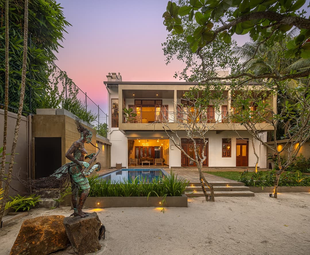 Yahva Bentota villa exterior with pool, garden and pink evening sky