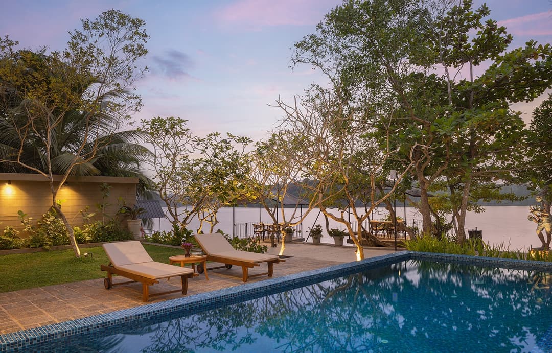 Yahva Bentota villa pool deck with sun loungers at sunset beside Dedduwa Lake
