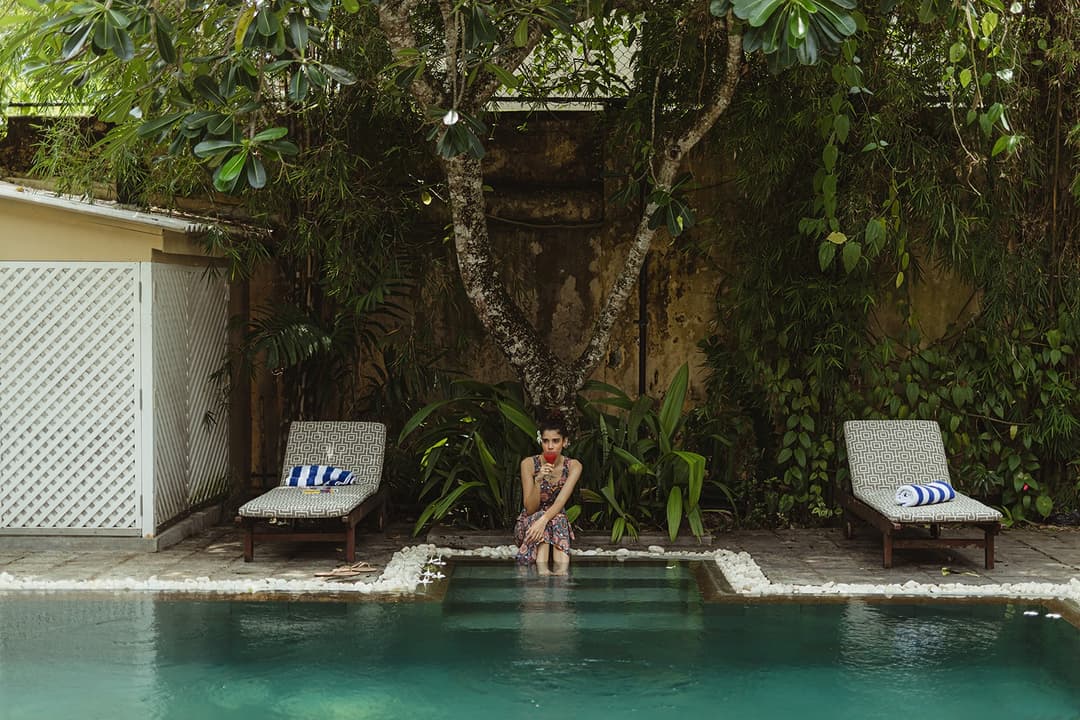 32 Middle Street Galle Fort pool with woman on sunlounger and lush tropical garden