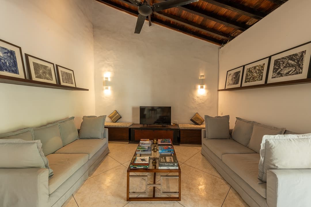 Villa lounge with cream sofa, framed art and colonial interior in Galle Fort