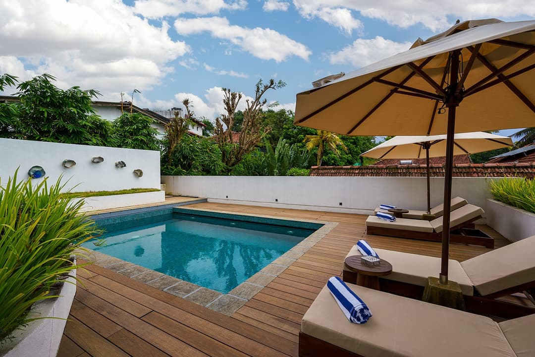 Elliot House Galle pool deck with timber sun loungers and tropical garden