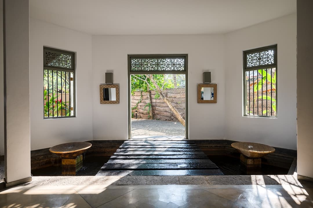 Beachfront villa arched corridor with pool and ocean visible beyond Unawatuna