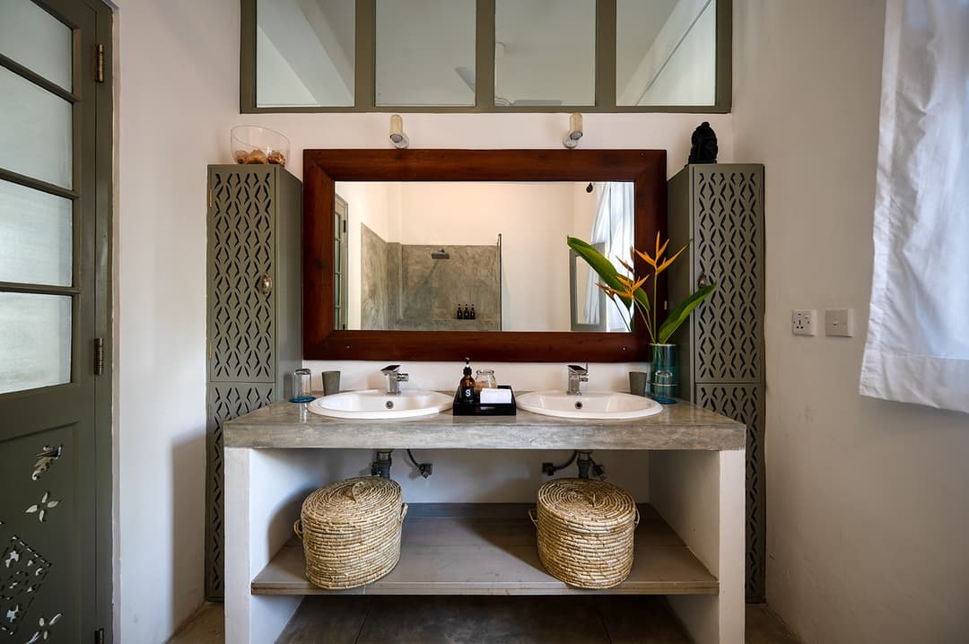 Beachfront villa ensuite bathroom with basin and natural stone mirror surround