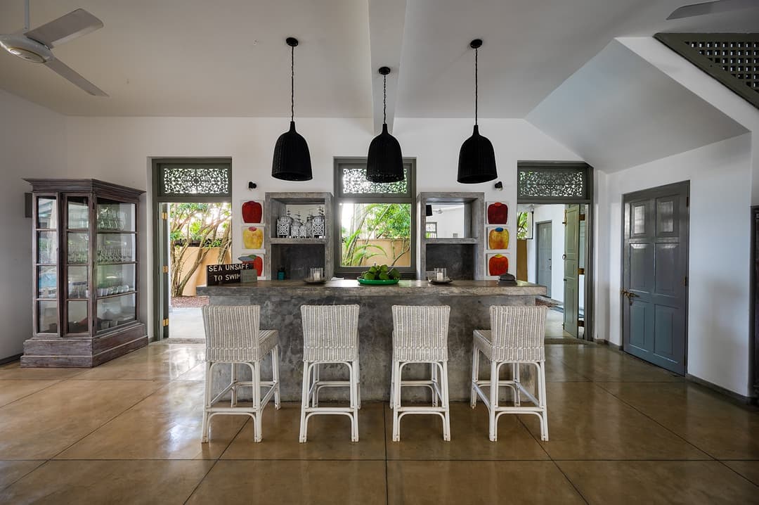 Beachfront villa living room with blue sofa and grey louvred shutters Unawatuna