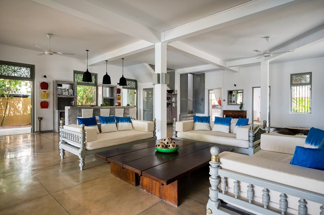 Beachfront villa wide open plan living room with artwork and blue accents